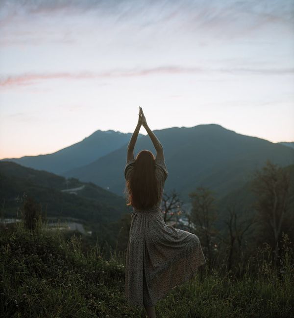 Person feeling energized and stretching in a natural landscape.
